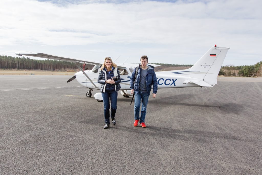 Christian Hieff und Manon Domizlaff stehen nach der Landung in Berlin vor dem Flugzeug